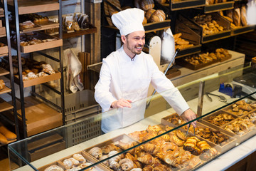 Male baker is offering fresh tasty bun