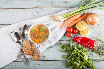 Delicious homemade vegetable soup close-up on a blue wooden table.