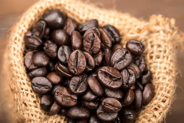 Coffee beans in sack on wood table