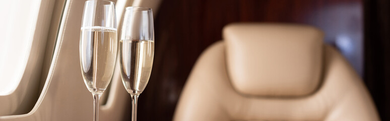panoramic shot of champagne glasses in private jet