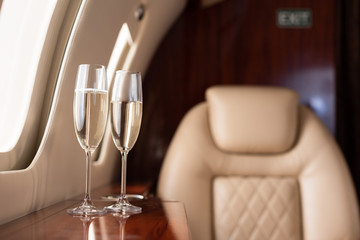 selective focus of interior of plane with champagne glasses for trip