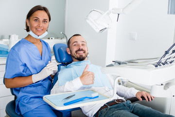 Man is satisfied in chair after treatment in dental office