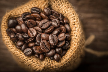 Coffee beans in sack on wood table