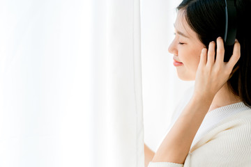 Fototapeta premium happiness beauty asian woman enjoy song music with headphone medium shoy on in living room white curtain background