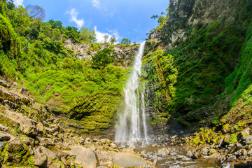coba rondo waterfall inside a green forest in malang, east java, indonesia