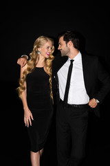 smiling man hugging attractive girlfriend isolated on black
