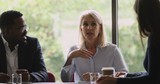 Middle aged female company boss speak during corporate group meeting