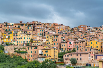 Fototapeta na wymiar Colorful Buildings in Siena Italy with dark cloudy sky