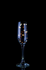 Party concept Glass of champagne with light pearls inside.