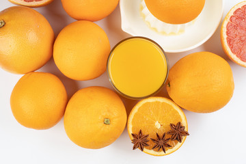 Fresh orange cinnamon star anise clove spice juice in glass on white yellow background