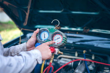 Auto mechanic Worker hands holding and point to monitor to check and fixed car air conditioner...
