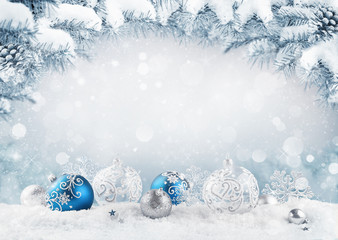 Merry Christmas card. Blue christmas balls and baubles on the snow with fir branches.