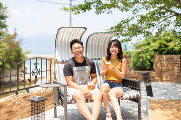 別荘の庭でビールを飲むカップル