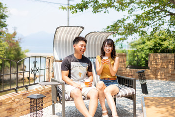別荘の庭でビールを飲むカップル