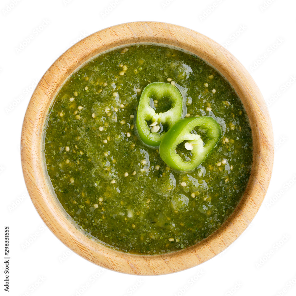 Wall mural tomatillo salsa verde. bowl of spicy green sauce isolated on white table, mexican cuisine. top view.