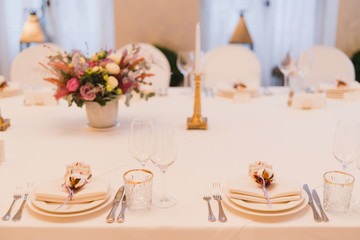 Coziness and style. Modern event design. Table setting at wedding reception. Floral compositions...