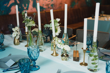 Coziness and style. Modern event design. Table setting at wedding reception. Floral compositions...