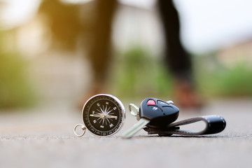 A compass and car key on road background, journey of life concept
