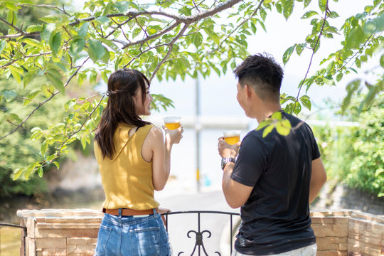 別荘の庭でビールを飲むカップル