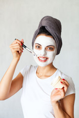 Smiling woman applying clay mask