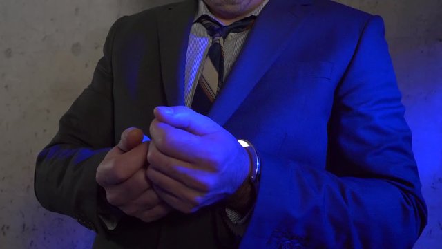 Businessmen in handcuffs offering cash money as bribery to get liberated.