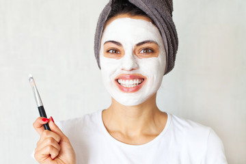 Home spa. Smiling woman applying clay mask