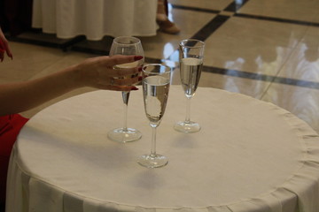 CHAMPAGNE IN THE RESTAURANT IN THE HAND OF A GIRL IN RED