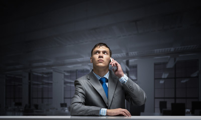 Young man talking on phone and looking upward.