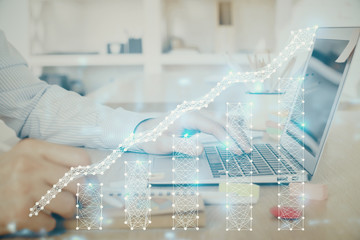Multi exposure of stock market graph with man working on laptop on background. Concept of financial analysis.