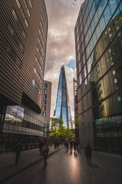 LONDON - APRIL 26, 2018: People walking towards the Shard building in London at sunset