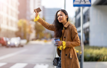 Woman calling taxi on city street