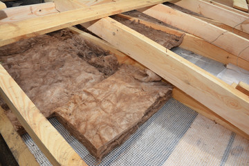 Attic Roof Insulation. Close up on insulation layers of mineral wool insulation, house roof...