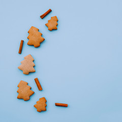 Holiday cookies in the shape of Christmas tree on light blue background. Copy space.