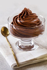 chocolate mousse cream dessert in a glass vase on a light background