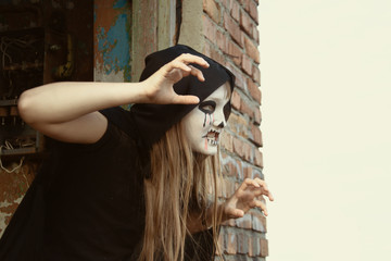 Naklejka premium Zombie crawls out from an abandoned house. Toned. Halloween and day of the dead concept