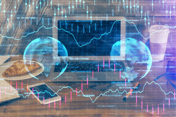 Double exposure of graph and financial info and work space with computer background. Concept of international online trading.