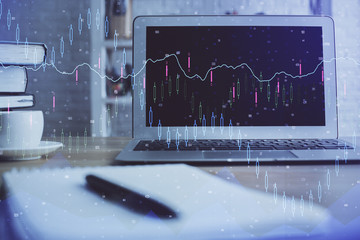 Financial graph colorful drawing and table with computer on background. Multi exposure. Concept of international markets.