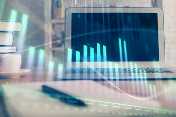 Stock market chart hologram drawn on personal computer background. Double exposure. Concept of investment.