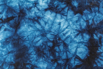 Abstract background. Texture of the fabric is decorated with uneven dark and light spots of blue. Beautiful grunge effect.