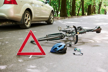 Police is here. Bicycle and silver colored car accident on the road at forest at daytime