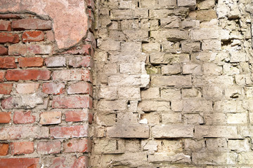 Old wall of gray and red broken bricks, background and texture