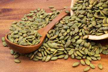Pumpkin seeds with wooden spoon and wooden bowl