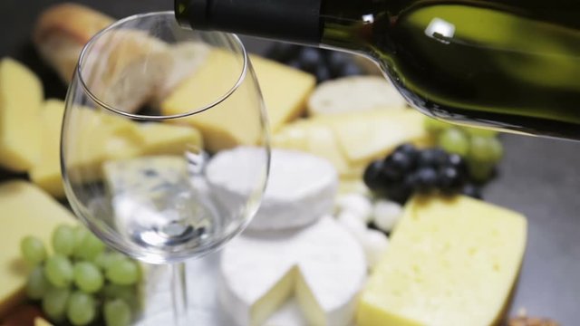 assorted cheeses, soft, hard, rennet and brine, and a glass of red wine.