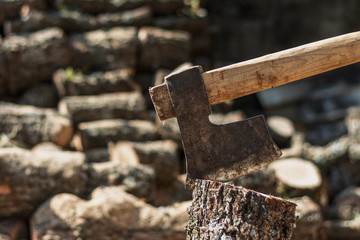 Rusted hatchet in a tree log