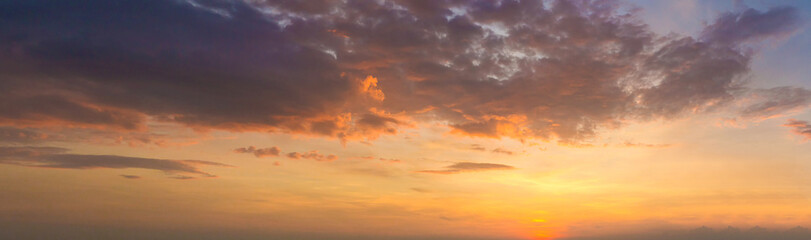 Panoramafoto Dämmerung Himmelshintergrund. Bunter Sonnenunterganghimmel und -wolke. Lebendiger Himmel im Dämmerungszeithintergrund. Feuriger orangefarbener Sonnenuntergangshimmel. Schön