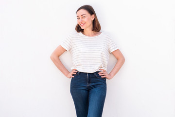 attractive older woman smiling with hands on hip by white background