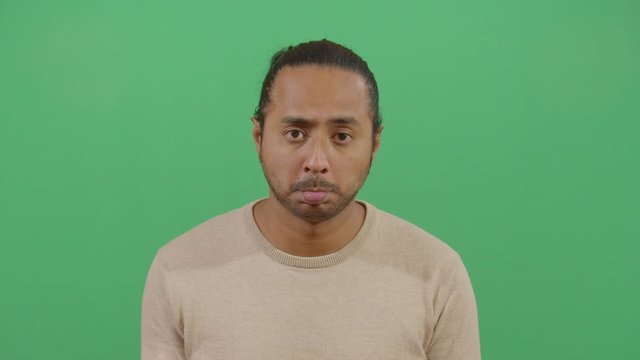 Facial Expression Of A Adult Man Pouting. Studio Isolated Shot Against Green Screen Background