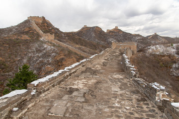 This section of the Great Wall is Jinshanling, a wild and unrestored part with scenic views. Near Beijing during cloudy day. Damaged Great Wall of China, Jinshanling, Beijing, China, Asia. UNESCO site