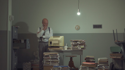 Businessman searching for files in a messy office