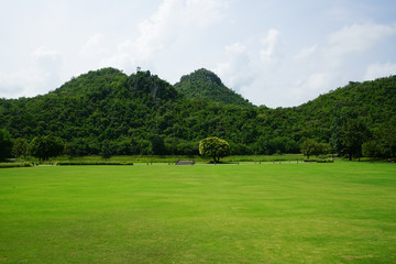 View of green park with the waterworks, white cloud and mountains 